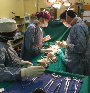 From left: Scrub nurse, visiting resident, and Dr. Green at Kibogora Hospital